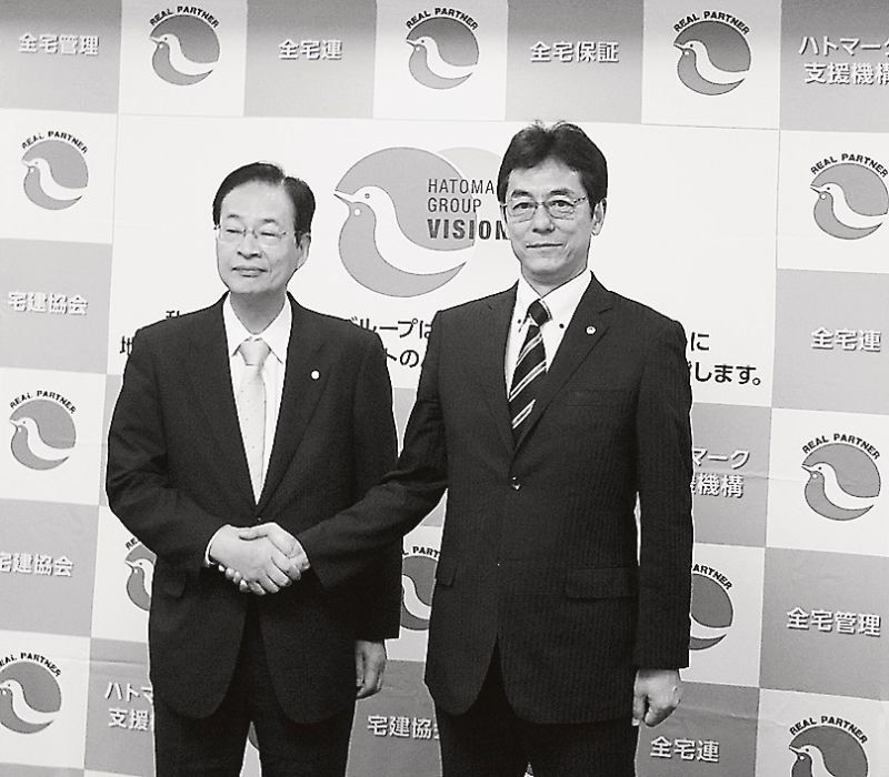 事業提携し、がっちり握手する和氣ハトマーク機構理事長(右)と能登住宅保証機構社長