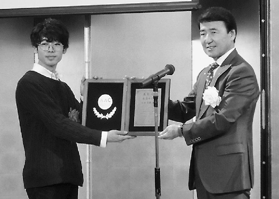 服部社長(右)から表彰状を受け取る白谷さん
