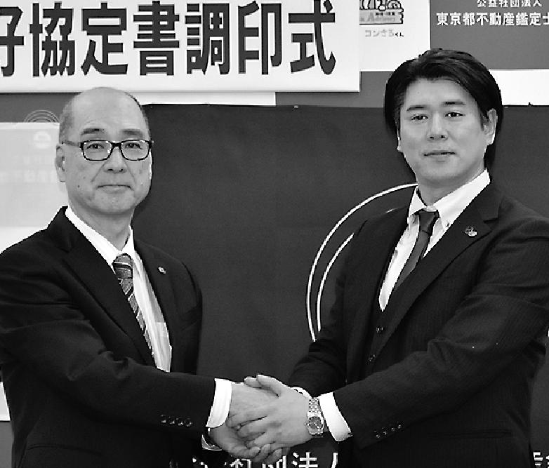 握手する佐藤会長(右)と峯岸会長