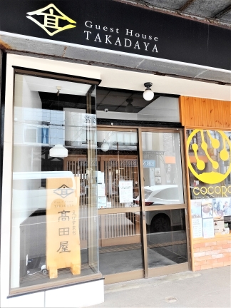 玄関に木彫り看板。隣がテナントのコーヒー屋だ