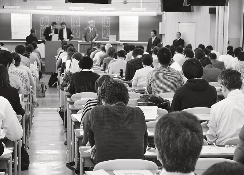 緊張の面持ちで試験監督員からの説明を待つ受験者たち。来年から資格名称が変わるため、「宅地建物取引主任者」の名称としては今年が最後。約19・2万人が受験した=東京都内の会場で