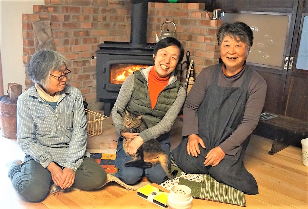 薪ストーブの前で談笑するメンバー