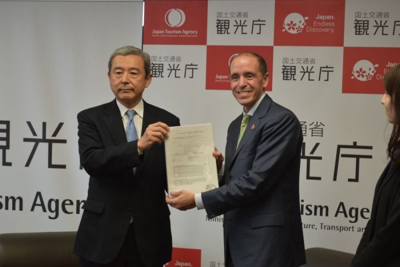 田村観光庁長官(左)に申請書類を手渡すエアビー責任者のレヘイン氏