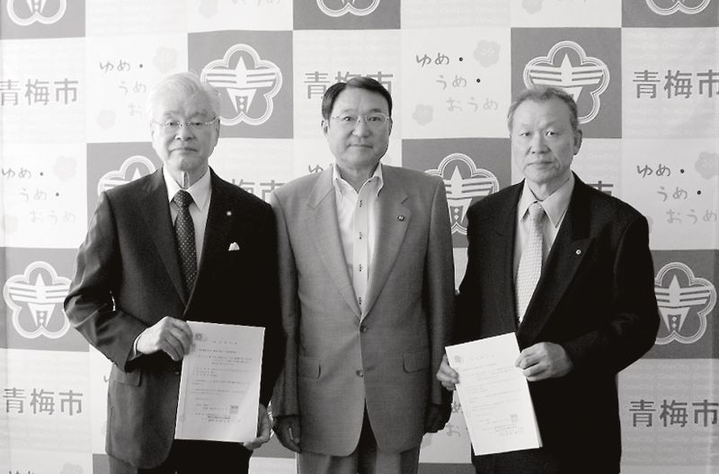 業務委託契約書を取り交わす浜中啓一青梅市長(中)と石井支部長(右)、原嶋支部長