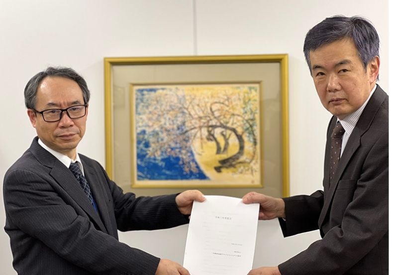 政策提言書を不動産流通推進センターの丸尾常務理事（左）に渡す真鍋氏