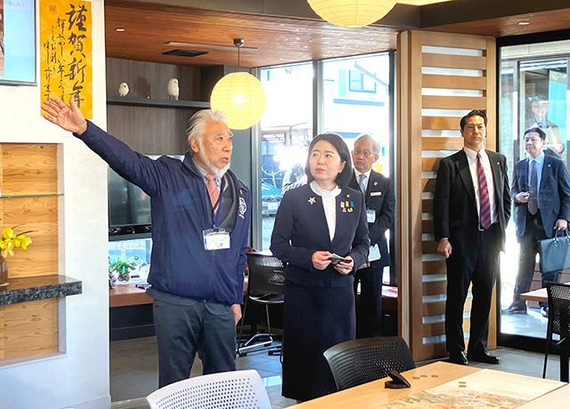 吉井座長(左)から「野七里テラス」の説明を受ける自見大臣(中央)