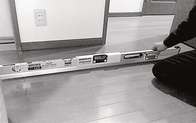 水平器を使って、床の傾き具合を検査している。居宅の様々な箇所の検査が求められるようになる