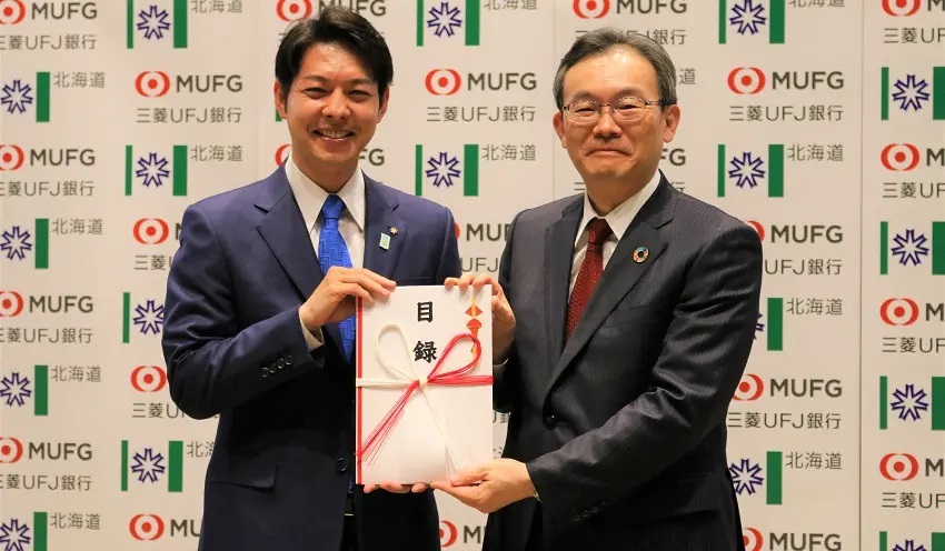 鈴木知事(左)に寄付金5億円の目録を手渡す半沢頭取(4月25日、銀行会館)