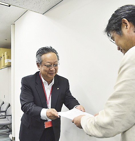 香山幹・住宅局市街地建築課長に要望書を手渡す関敏昭・マンション管理業協会副理事長(左)