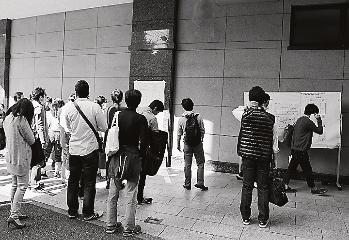 会場入りする前に自分が受ける教室などを確認する受験生たち