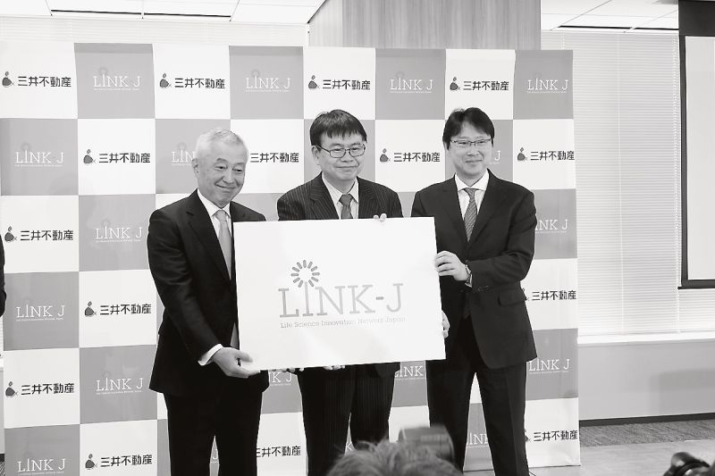 会見風景。岡野栄之理事長(中央)の左が菰田正信三井不社長、右が理事の植田俊三井不常務執行役員