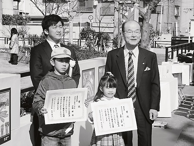 受賞者と記念撮影する水谷区長(左)と河社長(右))