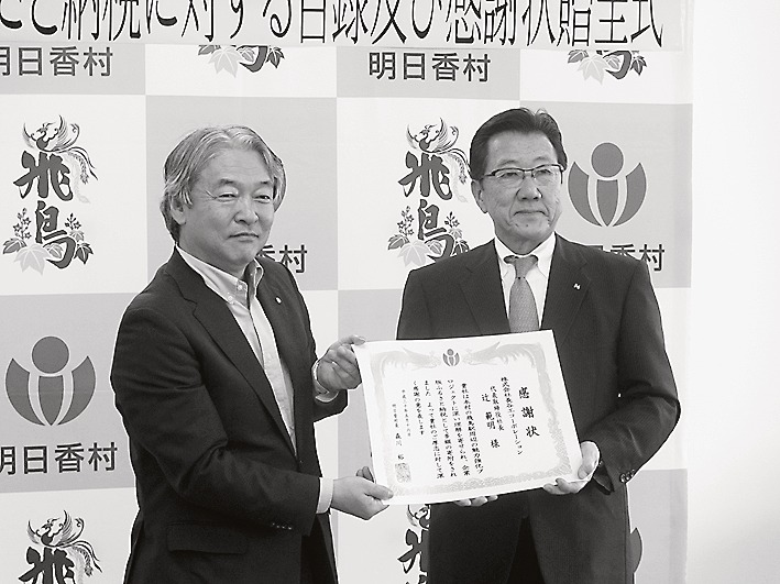 感謝状を受け取る村塚章介長谷工コーポレーション副社長(右)と、明日香村の森川裕一村長