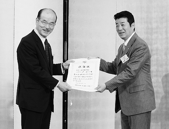 松井大阪府知事(右)から感謝状を受け取る河社長