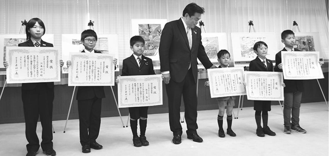 赤羽大臣(中央)と並ぶ受賞児童たち
