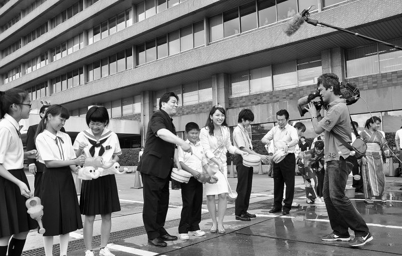 国土交通省の正面玄関前で8月1日に行われた「一斉打ち水」。羽田大臣も参加した。国交省職員のエコに対する啓発の意味もあり、今年で9回目。エコ推進のためには、まずは〝身内〟の意識改革が重要になるようだ