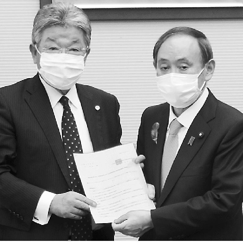 坂本会長(左)が菅官房長官に要望書を提出