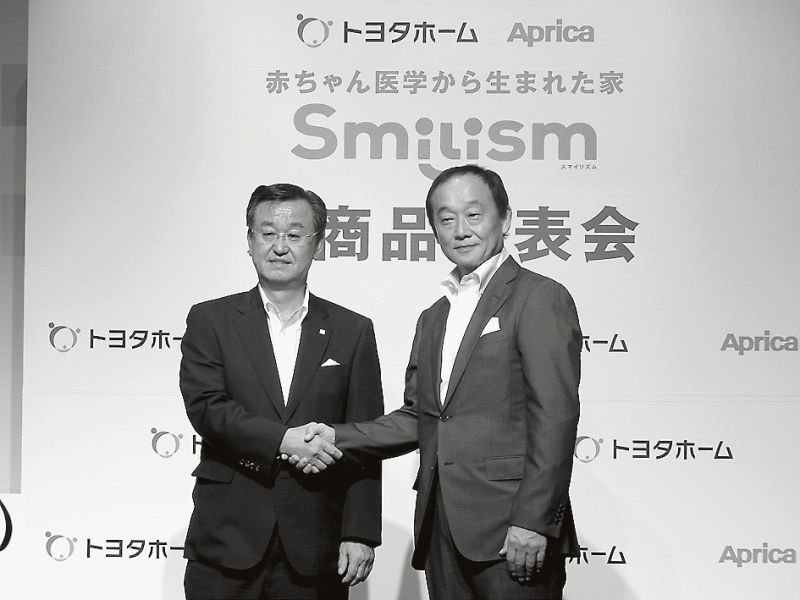 発表会で前田社長と握手する山科社長(左)