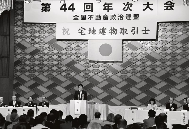 6月27日に開催された全政連の年次大会。会場には宅地建物取引士の名称変更を祝う横断幕が掲げられた。宅建議連の金子一義会長も駆け付け祝辞を述べた