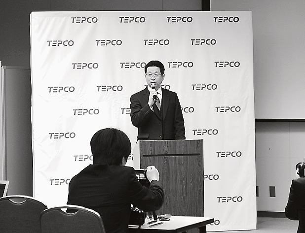 会見に立つ佐藤常務