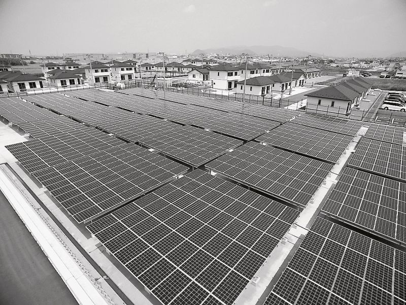 防災調整池に設置した太陽光発電システムと災害公営住宅団地
