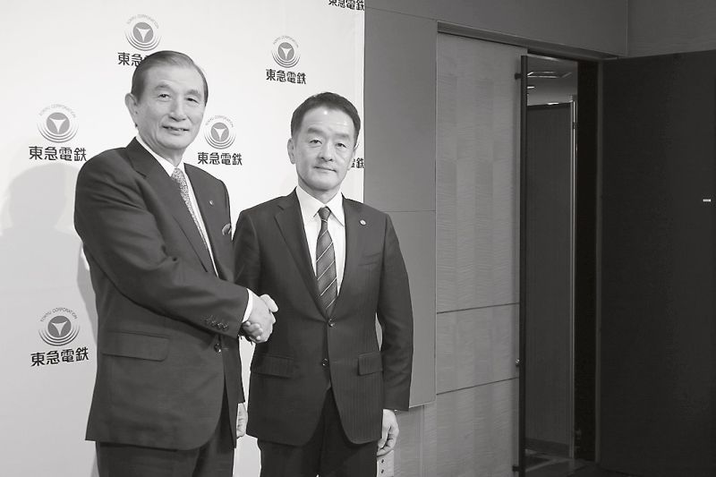 会見後に握手する野本社長(左)と高橋次期社長